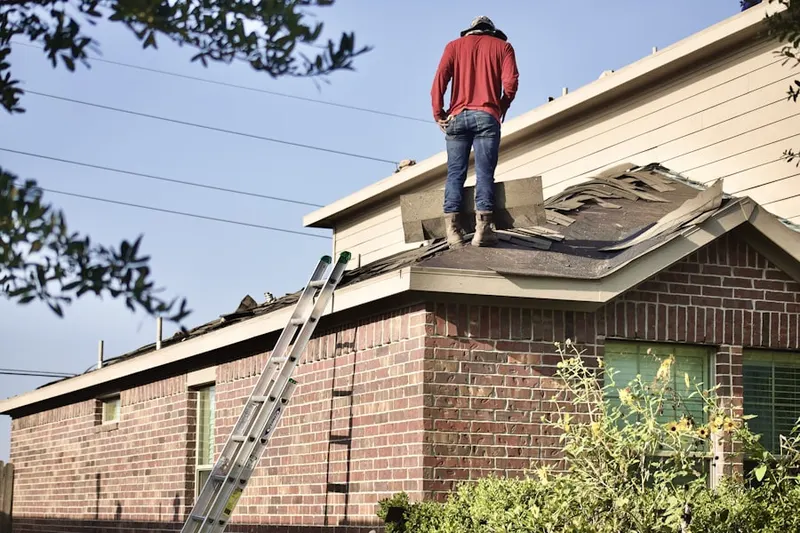 Professional roofer working on a residential roof in Titus Estates
